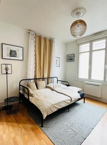 a bedroom with a bed and a large window at Beau studio cosy et meublé Loos lez Lille, France in Loos