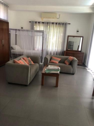 a living room with two couches and a coffee table at Hotel Paradiso, in Unawatuna