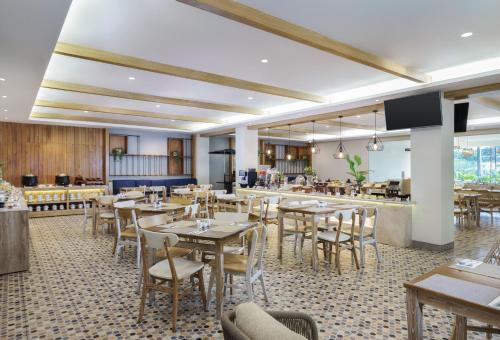 プラヤにあるSwiss-Belcourt Lombokのテーブルと椅子とバーのあるレストラン