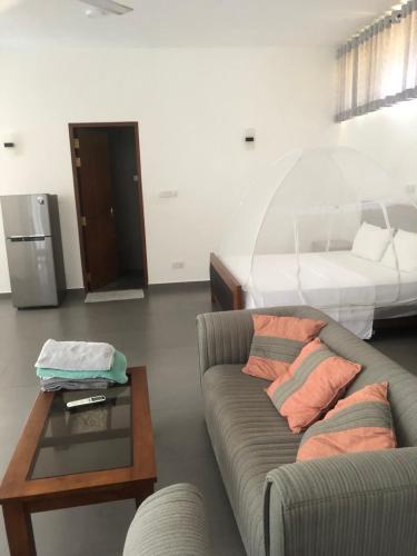 a living room with a couch and a bed at Hotel Paradiso, in Unawatuna