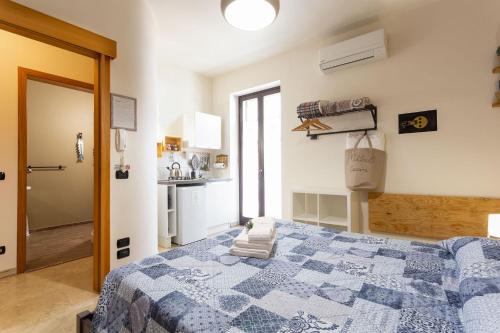a bedroom with a blue and white bed and a kitchen at Pura Vida Barocca in Ragusa