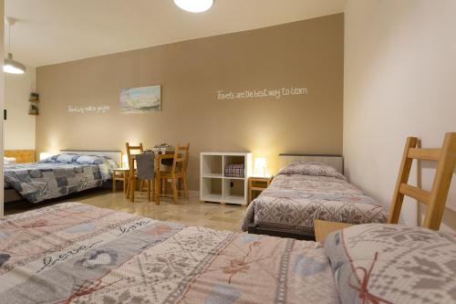 a room with two beds and a table with a tableablish at Pura Vida Barocca in Ragusa