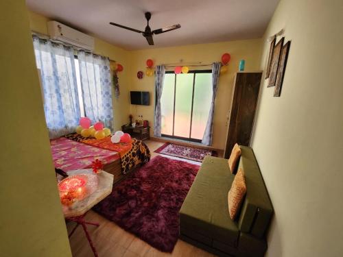 a living room with a bed and a couch at Bhumi Holiday Home in Alibaug