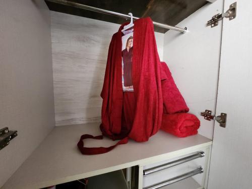 a bathroom with red towels hanging on a shelf at Bhumi Holiday Home in Alibaug