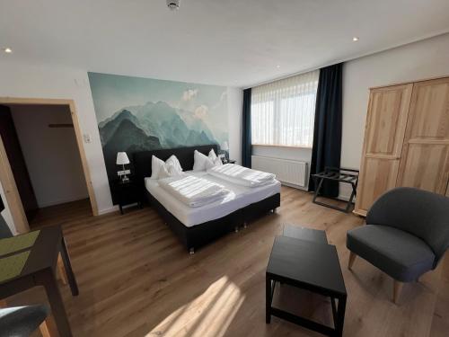 um quarto com uma cama, um sofá e uma cadeira em Hotel Berghof em Berg im Drautal