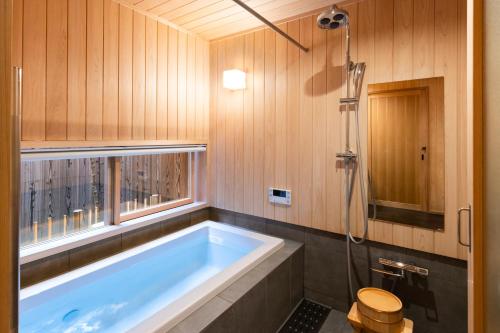 a bath tub in a bathroom with a window at Rinn Premium Machiya Koki in Kyoto