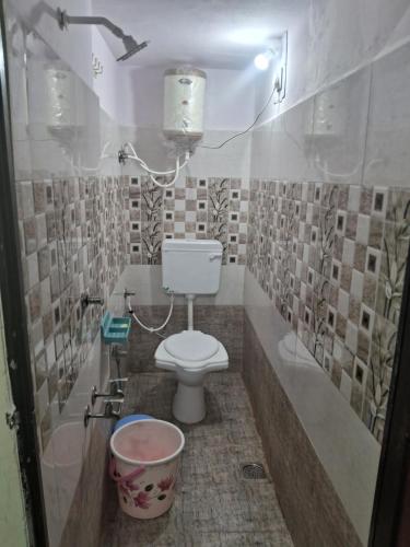 baño con aseo y cubo en Shree Mohan Home stay, en Ujjain