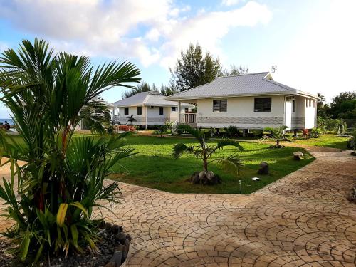 una casa con un camino empedrado frente a una casa en Moanaura Lodge, en Atimaono