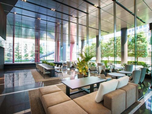 a lobby with a couch and tables and chairs at Villa Fontaine Grand Tokyo Tamachi in Tokyo