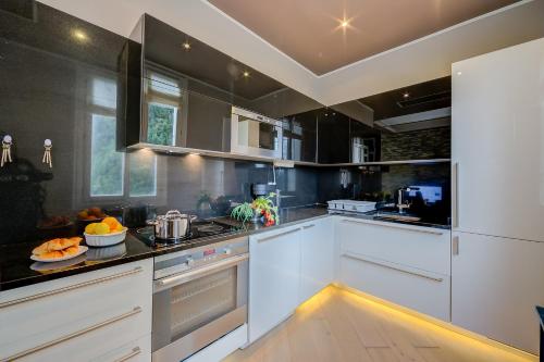 une cuisine avec des armoires blanches et un comptoir dans l'établissement Appartement Baous 300m de la mer - Happy Rentals, à Beaulieu-sur-Mer