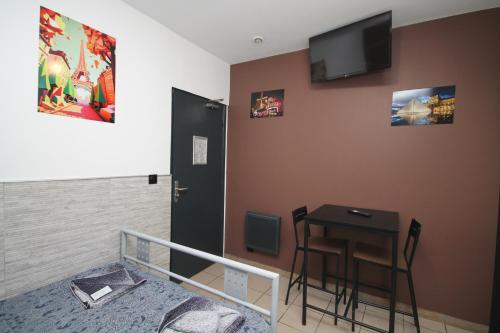 une chambre avec un lit, une table et une télévision dans l'établissement 05 - Chambre confort au calme avec TV WIFI, à Saint-Denis