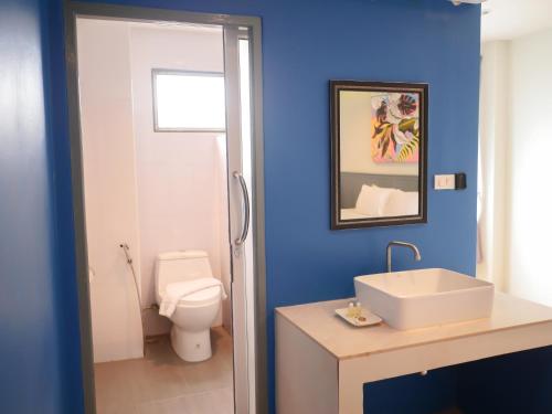 een blauwe badkamer met een toilet en een wastafel bij Xanadu Hotel Utapao in Rayong