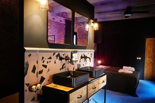 een badkamer met 2 wastafels en een bed bij Dormsy aparthotel House in Arenys de Mar