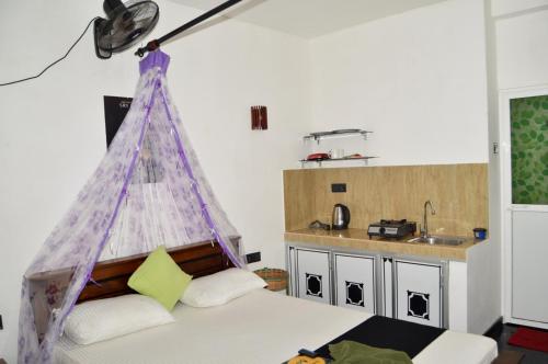 ウェリガマにあるKosi Giggles Resortのベッドルーム1室(テント付きのベッド1台付)