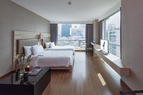 Postel nebo postele na pokoji v ubytování Adelphi Suites Bangkok