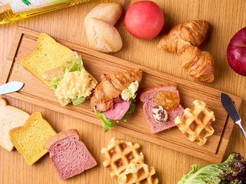 a group of sandwiches and waffles and pastries on a table at Hotel Musse Kyoto Shijo Kawaramachi Meitetsu in Kyoto