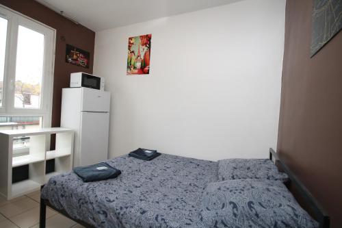 a small bedroom with a bed and a white refrigerator at 08 - Chambre proche Paris et Transports avec TV WIFI in Saint-Denis