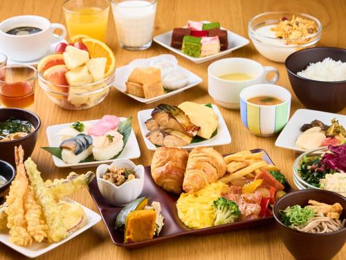 a table full of different types of food on plates at Hotel Musse Kyoto Shijo Kawaramachi Meitetsu in Kyoto