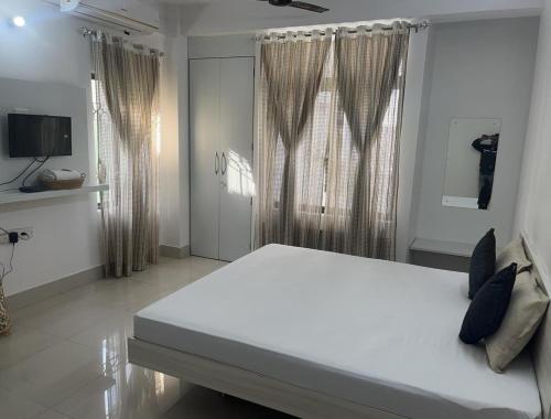 a bedroom with a large white bed with a window at GRUHAM SOJOURN HOMESTAY in Guwahati