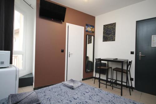 une chambre avec un lit, une table et une télévision dans l'établissement 09 - Chambre proche Paris et Transports avec TV WIFI, à Saint-Denis