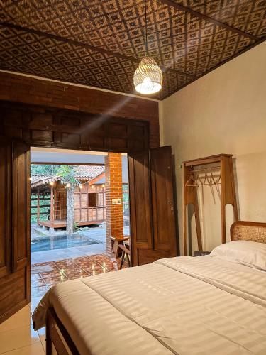 a bedroom with a bed and a view of a courtyard at Ndalem Rahadi in Kaliurang