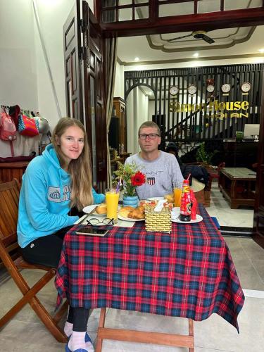 a man and a woman sitting at a table with food at Simon House Hoi An in Hoi An
