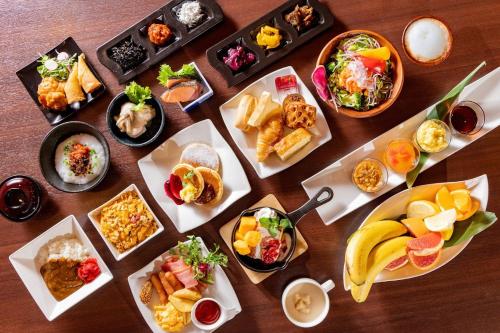 Hotel Wing International Premium Tokyo Yotsuya في طوكيو: طاولة بها العديد من الأطباق المختلفة من الطعام