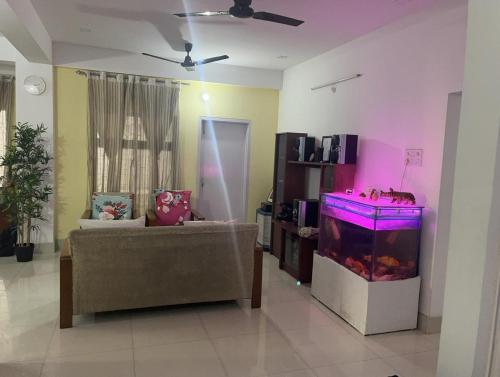 a living room with a fish tank and a couch at GRUHAM SOJOURN HOMESTAY in Guwahati