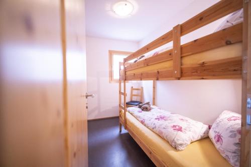 1 dormitorio con litera y escalera en Chasa Bazzell en Ftan