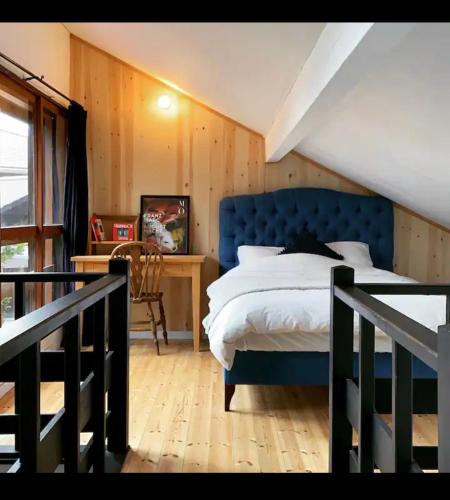 a bedroom with a blue bed and a desk at 4月リニューアルOpen! 全室エアコン完備! Cottage あかいやねｰ The Red Roof Cottage YamanakaKoｰ in Yamanakako