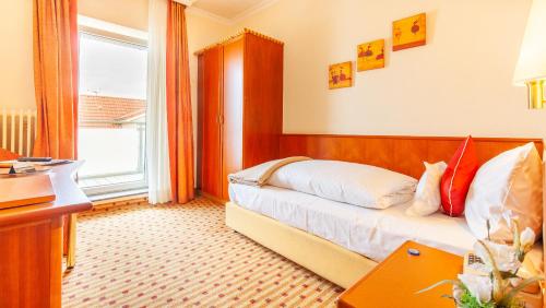 ein Hotelzimmer mit einem Bett und einem Fenster in der Unterkunft Hotel Friese in Norderney