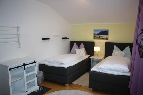 um quarto com 2 camas e uma secretária com um candeeiro em Appartment Krausberghof em Bad Hofgastein