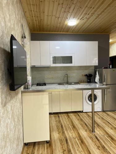 a kitchen with white cabinets and a sink at Buddy House Borjomi in Borjomi
