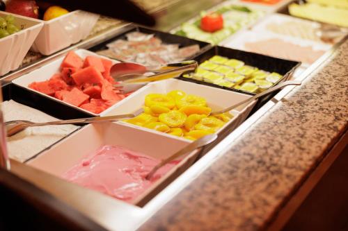 a buffet filled with different types of fruits and vegetables at Louvre Hotel in Gouvia