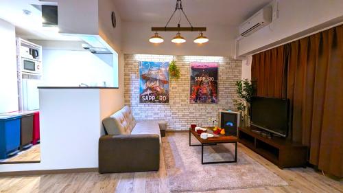 a living room with a couch and a tv at KIYAZA Station Sapporo 2 in Sapporo