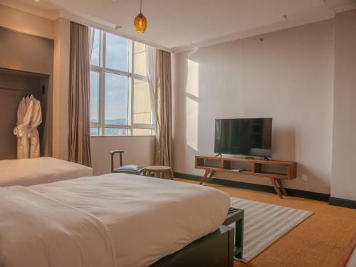 a hotel room with a bed and a flat screen tv at Sanna Boutique Hotel in Arusha