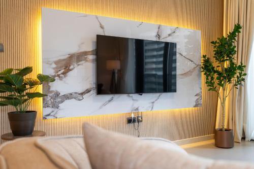 een woonkamer met een tv aan de muur bij Chic & Spacious 2BR l Burj & Fountain Views l near Dubai Mall l Pool l Gym in Dubai