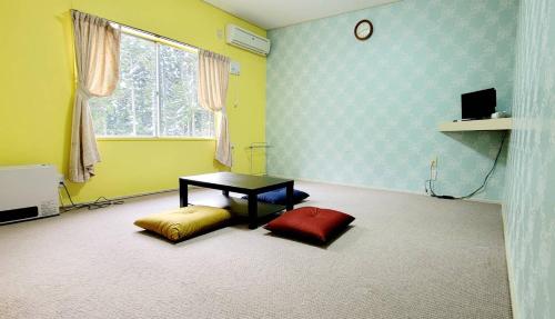a room with a table and two pillows in it at ロッジＴＯＮＢＯ・石打 in Minami Uonuma