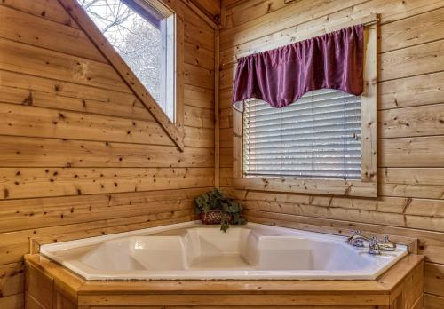 a bathroom with a tub in a log cabin at Whispering Creek #302 in Pigeon Forge