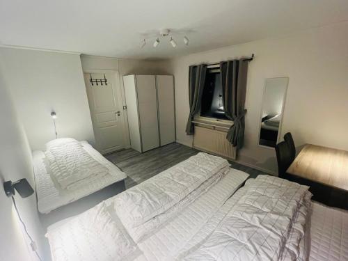 1 dormitorio con 2 camas blancas y ventana en Kiruna accommadation Sandstensgatan 24, en Kiruna