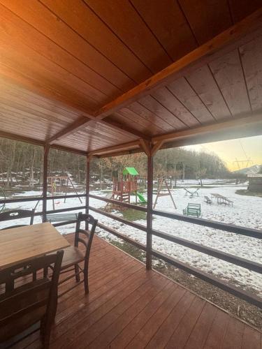 a wooden deck with a playground in the snow at B&B Snow Village Roccaraso in Roccaraso