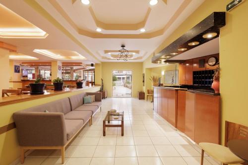 a lobby of a hospital with couches and a bar at Louvre Hotel in Gouvia