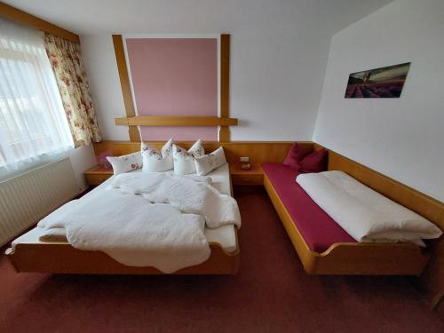 1 dormitorio con 2 camas y ventana en Apart Franzi, en Arzl im Pitztal