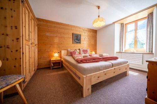 a bedroom with a bed in a room with wooden walls at Chasa Plazza Gronda in Lavin