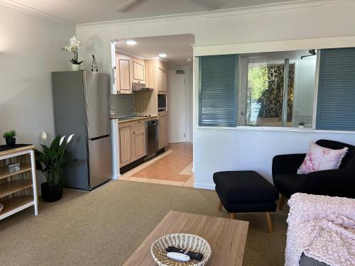 a kitchen and a living room with a refrigerator at Apartment 12 On Trinity Beach in Trinity Beach
