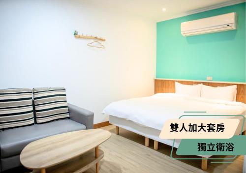 a bedroom with a bed and a couch and a table at 西湖柚子家民宿 in Xihu