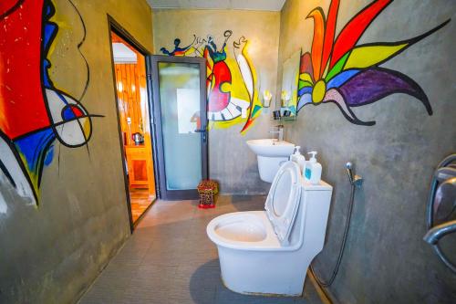 峰牙的住宿－Phong Nha Escape Bungalow，一间带卫生间的浴室和墙上的绘画