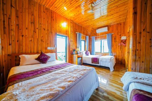 峰牙的住宿－Phong Nha Escape Bungalow，一间带木墙的卧室和一张位于客房内的床