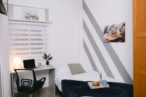 a bedroom with a bed and a desk with a laptop at Piso compartido Delyrent, SFJ in Jaén