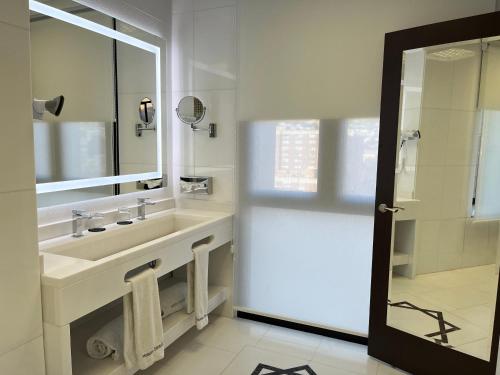 a white bathroom with a sink and a mirror at Hotel Saray in Granada